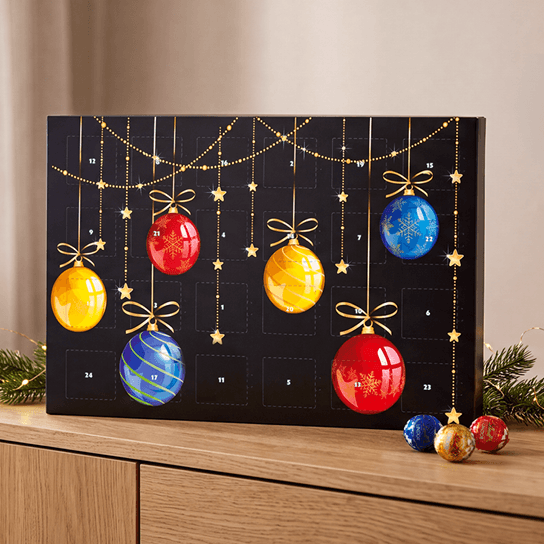 Bedruckter Adventskalender auf einem Sideboard stehend mit Lindt Lindor Kugeln
