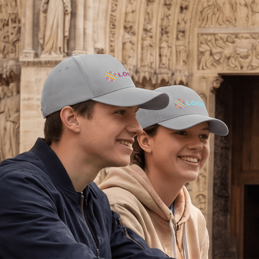 Zwei Menschen mit individuell bedruckten Beechfield-Caps vor einem Kirchenportal