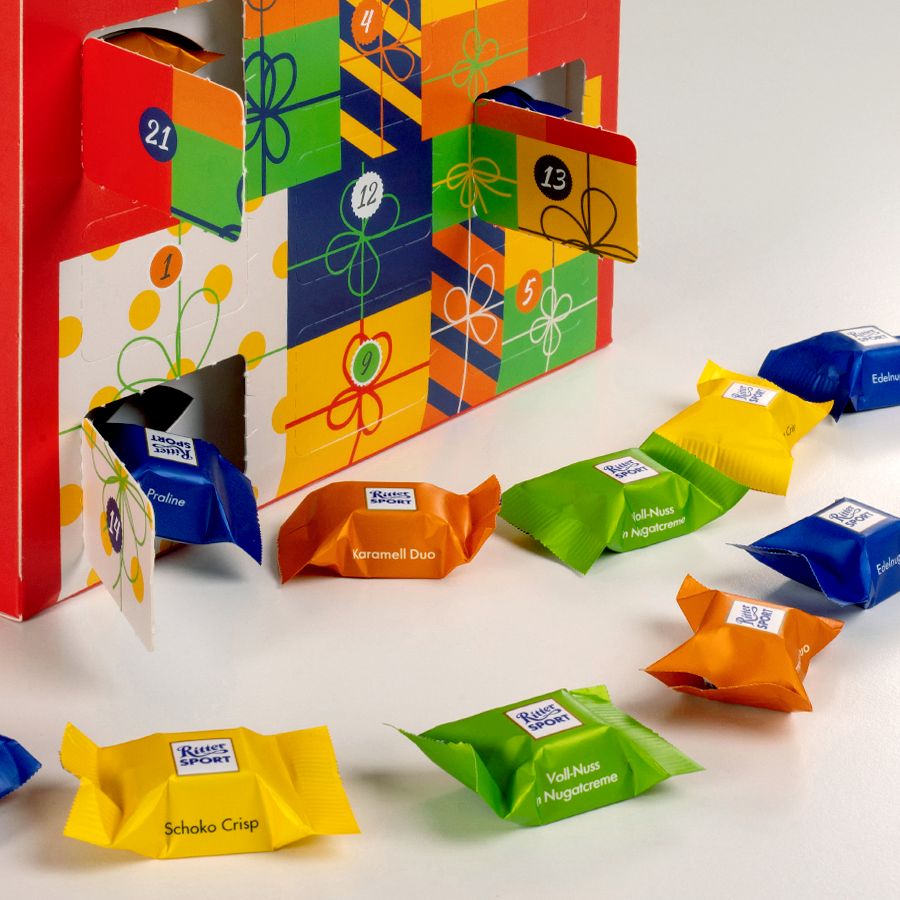 Detailansicht RITTER-SPORT-Adventskalender mit individuellem Druck und geöffneten Türchen inklusive Inhalt