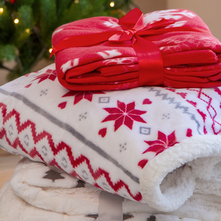 Ein Stapel kuschelige Weihnachts-Fleecedecken mit verschiedenen Motiven