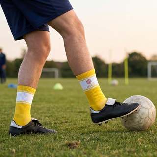Fussballspielende Person trägt gelbe, individuell bedruckte Gripsocken mit weissen Streifen am Bein