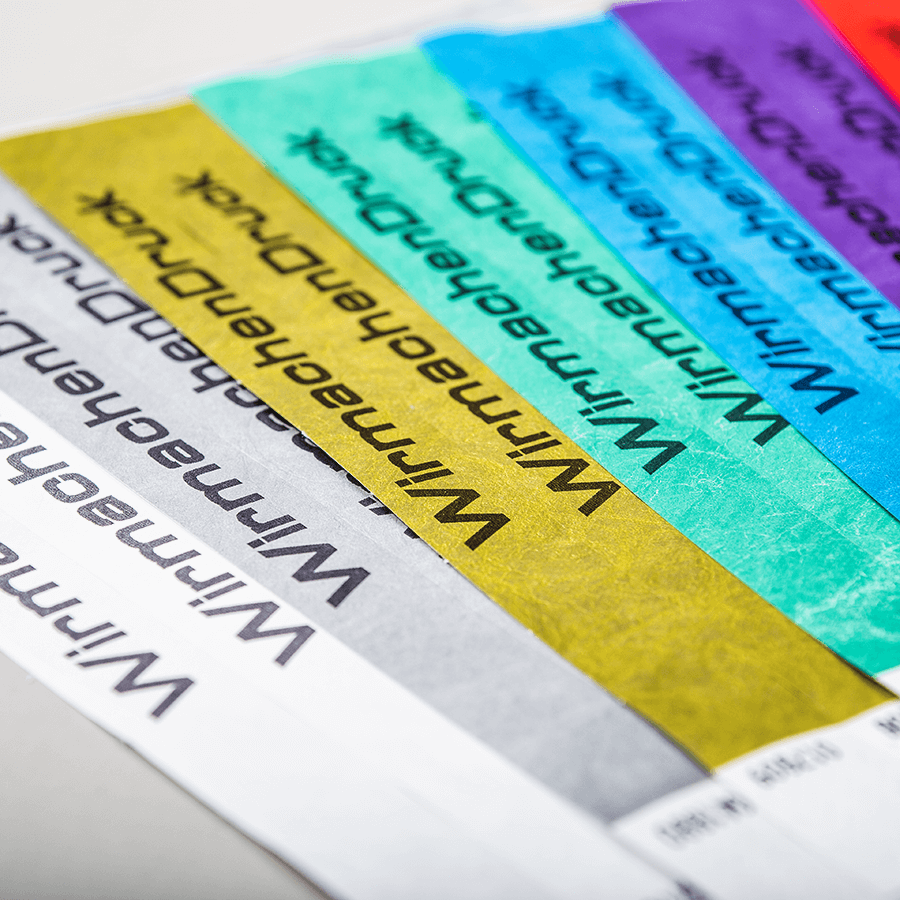 Detailansicht von verschiedenenfarbigen Kontroll- und Einlassbändern mit personalisierbarem Druck