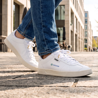 Eine Person unterwegs trägt bedruckte PUMA-Sneaker in Weiss