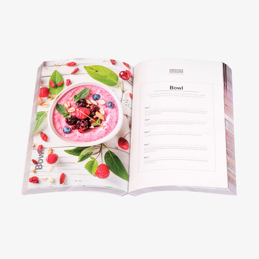 Aufgeschlagenes Softcover-Buch (12,5 x 19 cm) mit farbig bedrucktem Inhalt