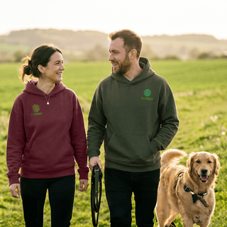 Ein Paar in bedruckten Stanley/Stella-Hoodies geht mit seinem Hund spazieren