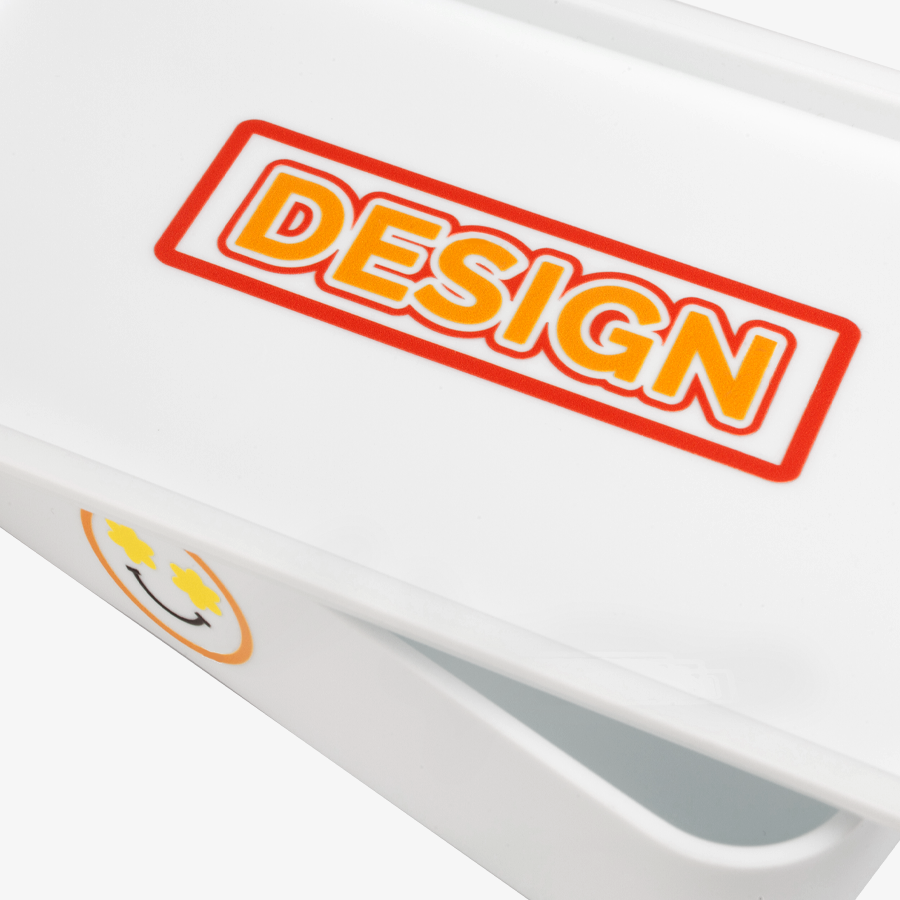 Individueller UV-DTF-Aufkleber in freier Grösse platziert auf dem Deckel einer weissen Lunchbox
