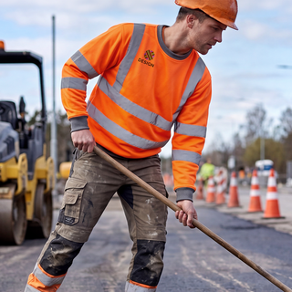 Ein Mann mit bedrucktem Warnschutz-Sweatshirt arbeitet im Strassenbau