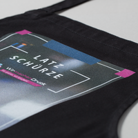 Stoffschuerze schwarz, farbig bedruckt, liegend