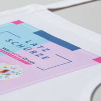 Stoffschuerze weiß, farbig bedruckt, liegend